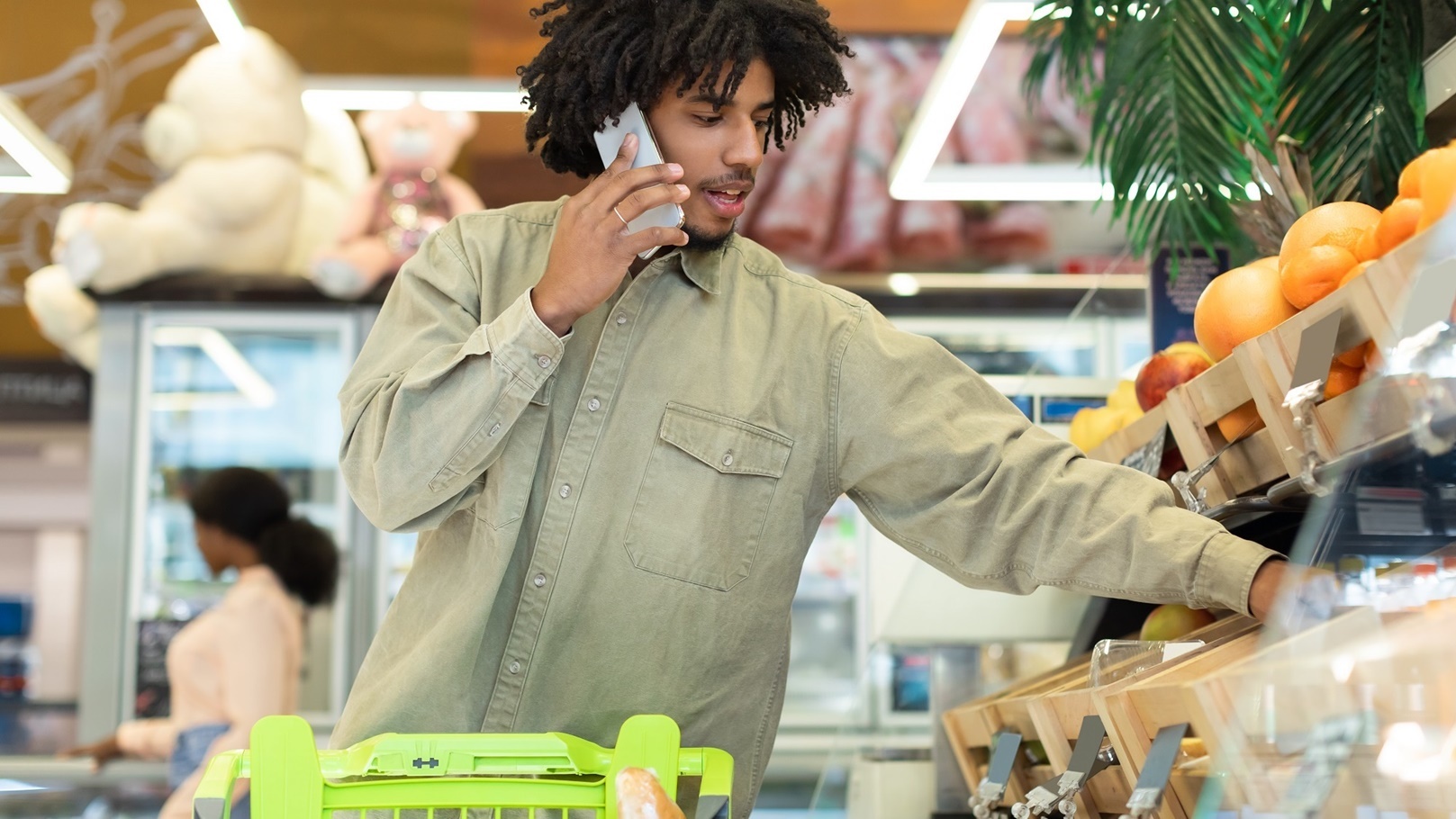 black-guy-talking-on-phone-choosing-fruits-shoppin-2022-10-07-02-55-52-utc