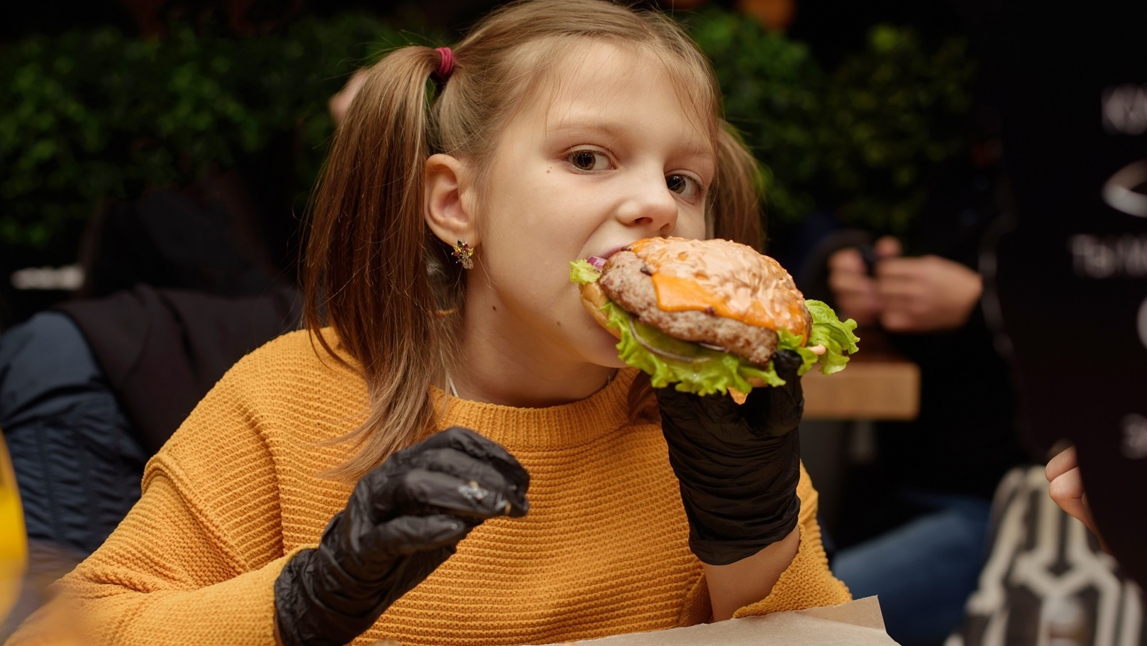 a-girl-eats-a-burger-with-black-gloves-2021-08-29-14-53-27-utc (1)