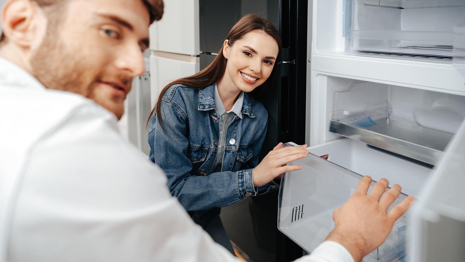 young-couple-selecting-new-refrigerator-in-househo-2021-09-02-11-00-51-utc