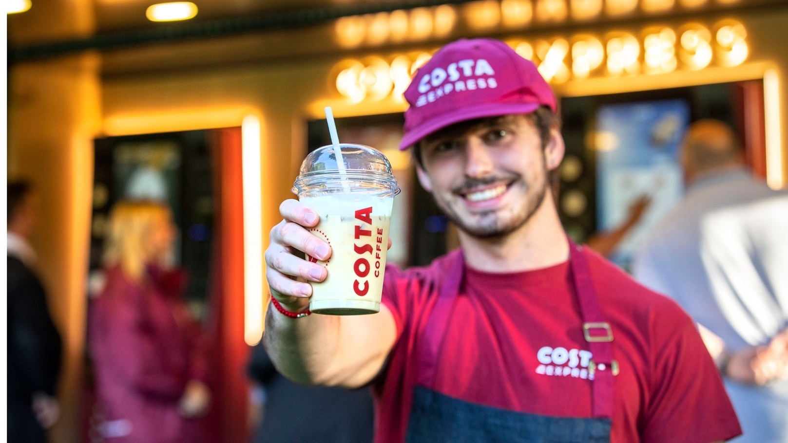 موظف بحد مقاهي Costa  يحمل مشروب الشركة