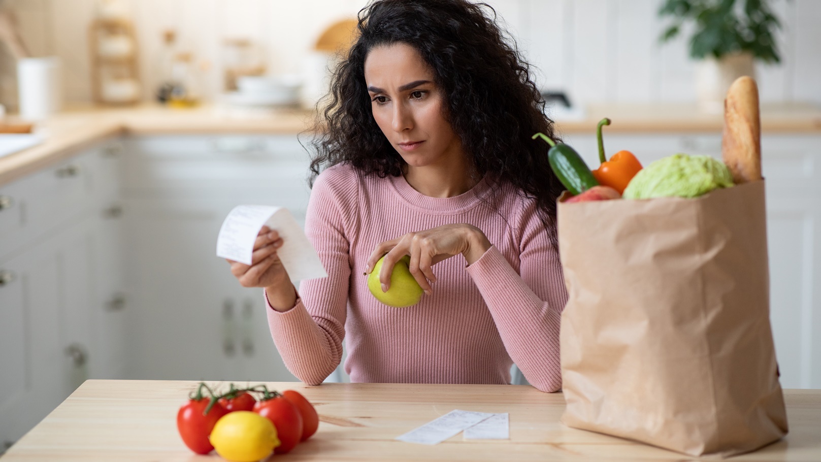 concerned-young-woman-checking-bills-in-kitchen-af-2021-09-02-05-08-17-utc