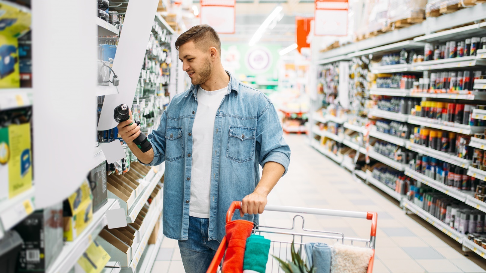 man-choosing-electric-screwdriver-in-supermarket-2021-08-26-16-26-59-utc