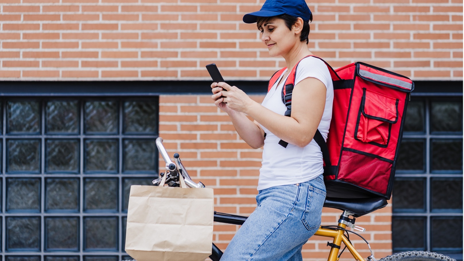 woman-with-red-backpack-holding-bag-of-food-in-cit-2022-02-16-22-28-23-utc