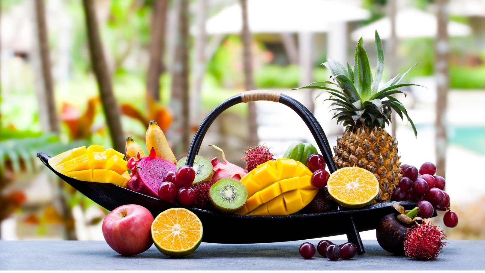 tropical-fruits-assortment-in-wooden-boat-outdoor-2021-08-26-16-29-54-utc