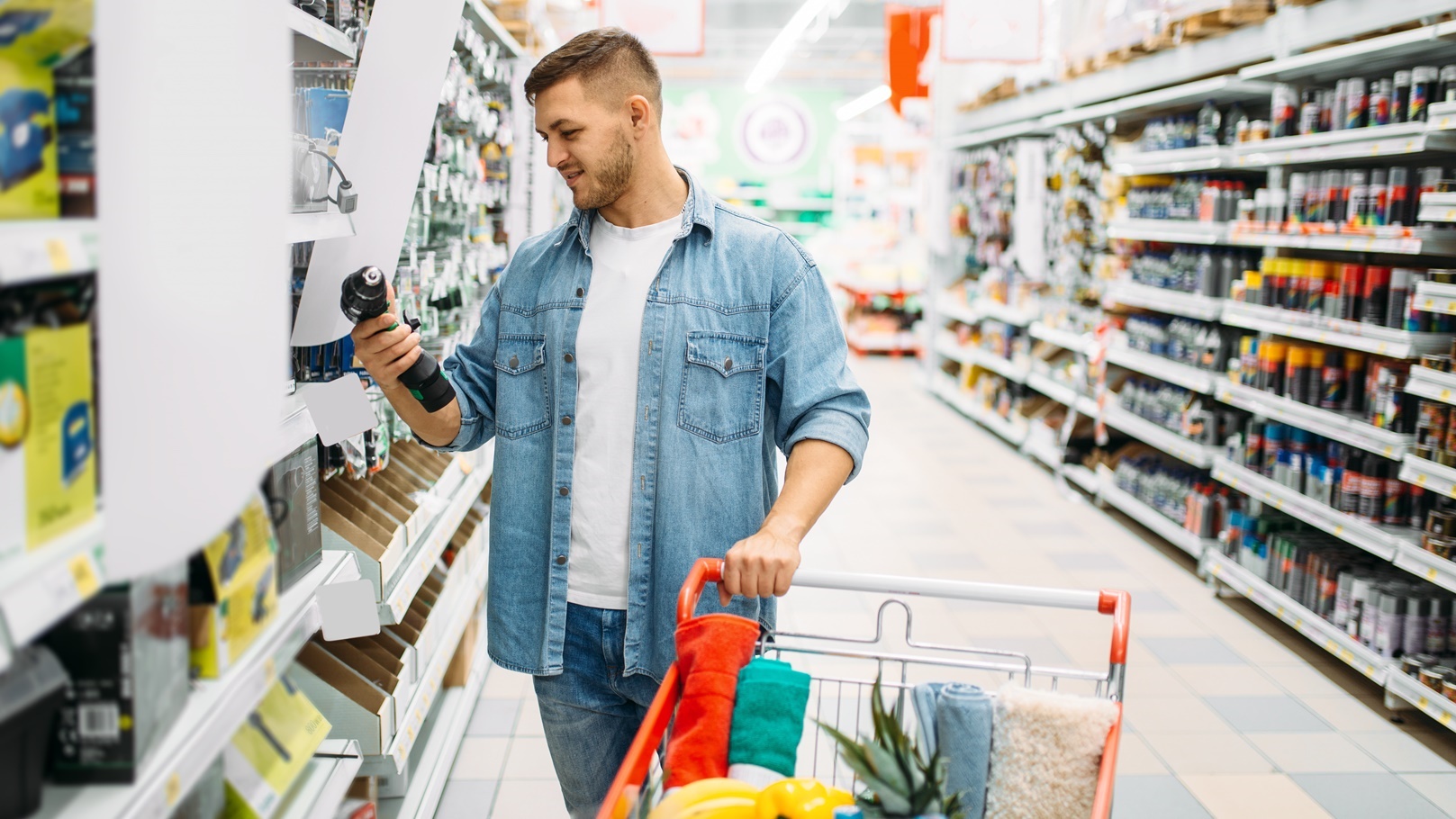 man-choosing-electric-screwdriver-in-supermarket-2021-08-26-16-26-59-utc