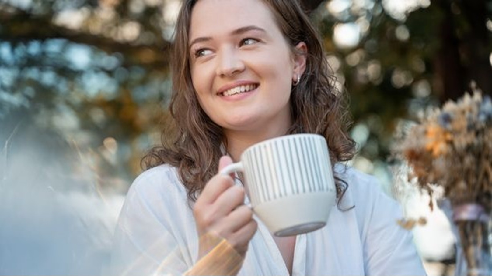 1_Young-pretty-curly-woman-drinking-coffee-tea-in-a-street-cafe-on-a-summer-day-with-a-happy-smile-on