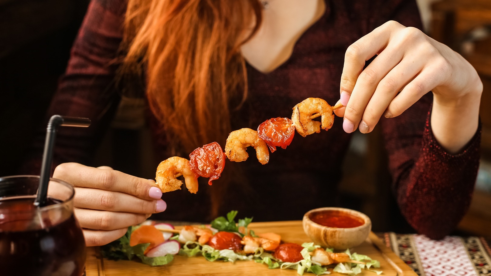 side-view-woman-eating-shrimp-on-a-skewer-with-veg-2021-08-31-16-11-54-utc