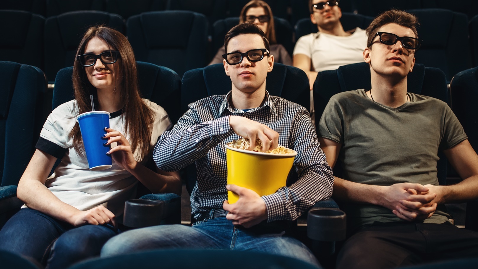 people-with-popcorn-watching-movie-in-cinema-2021-08-26-16-26-29-utc