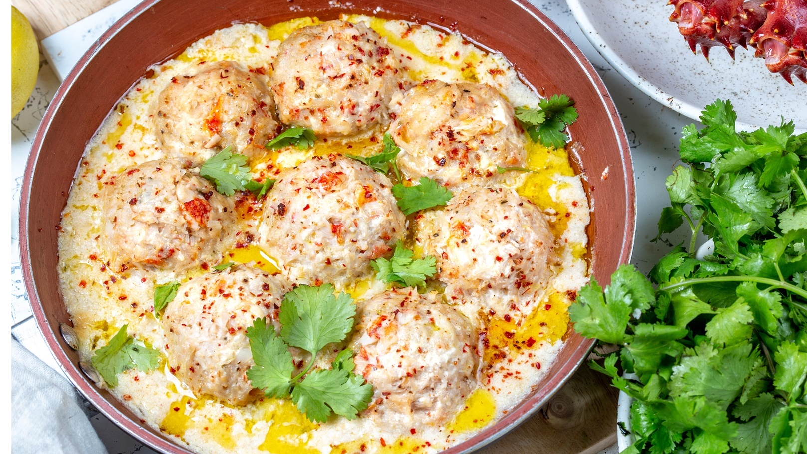 meatballs-in-white-creamy-sauce-in-red-pan-2021-08-28-05-26-41-utc