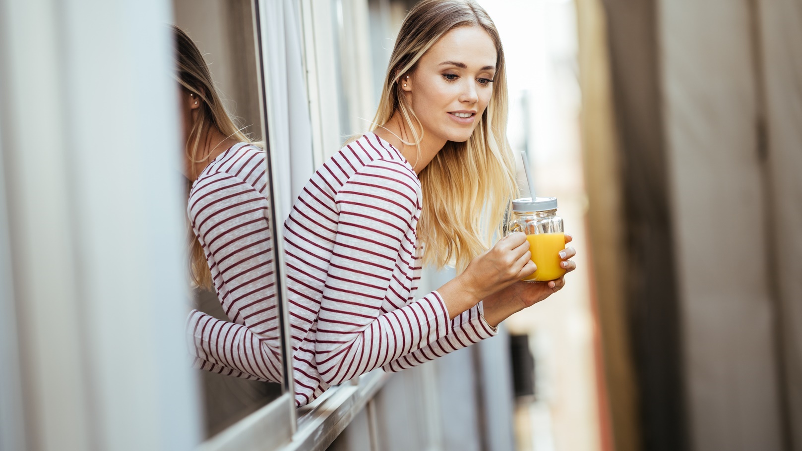 young-woman-drinking-a-glass-of-natural-orange-jui-2021-08-31-08-36-03-utc