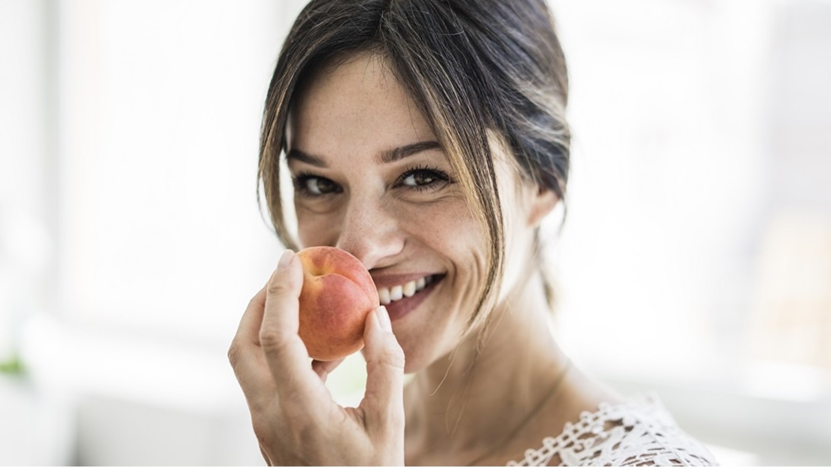laughing-woman-smelling-an-apricot-2022-03-08-01-23-47-utc