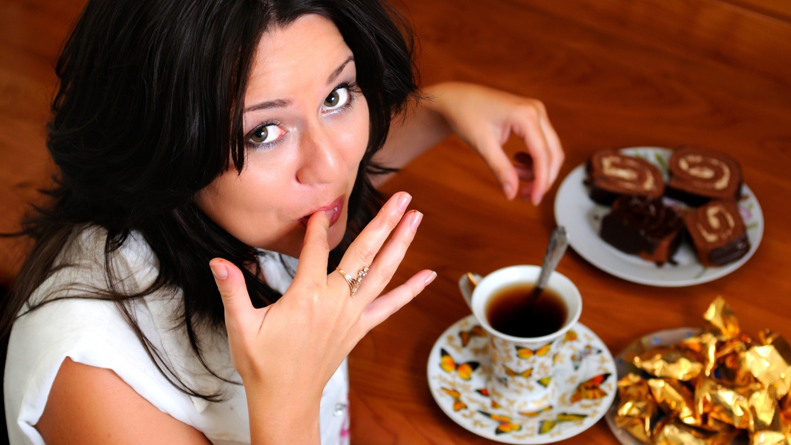 امرأة تتناول الحلويات