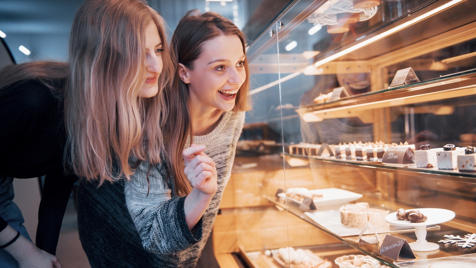 two-happy-attractive-girls-choosing-delicious-gana-2021-08-29-02-46-44-utc