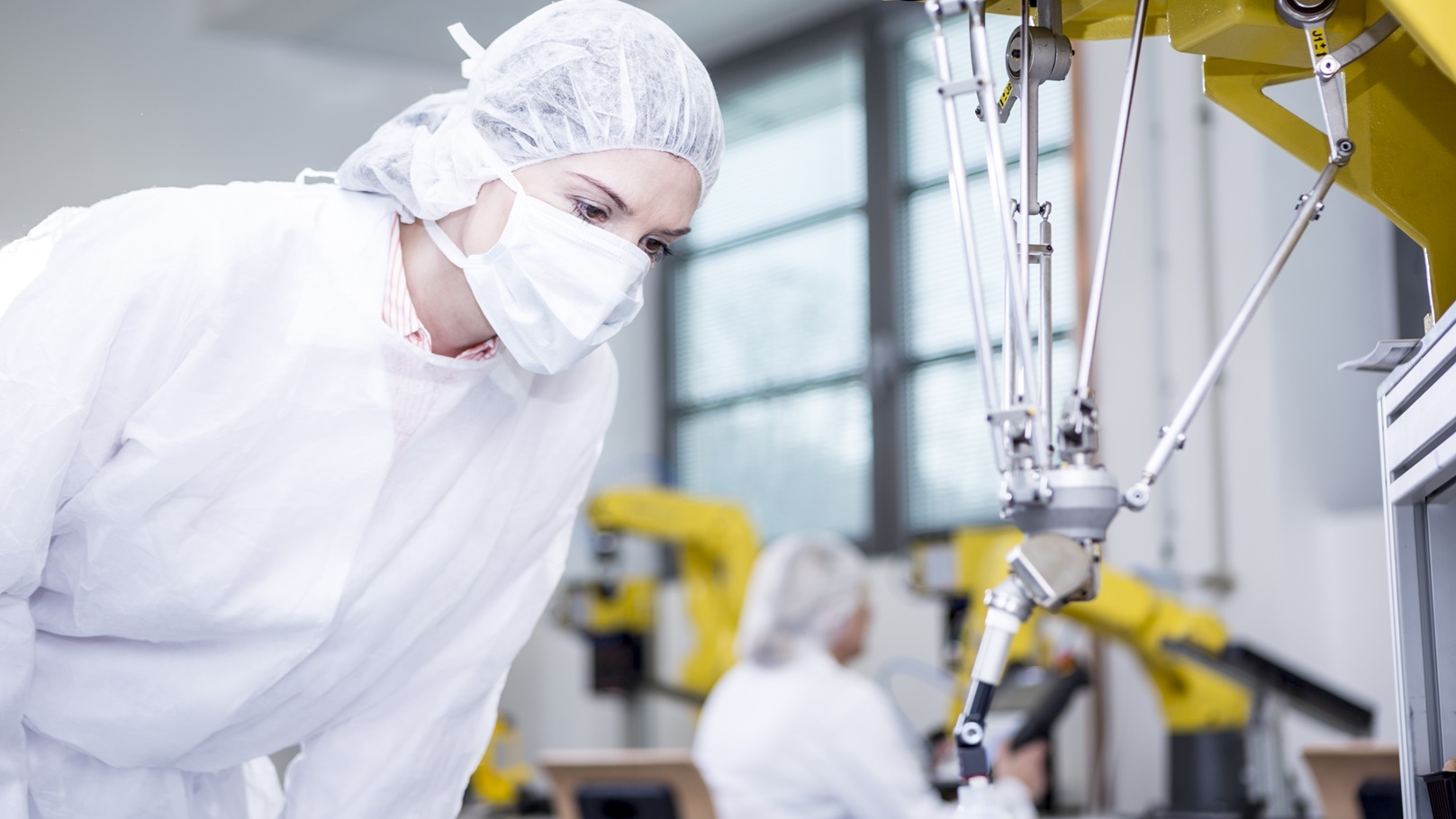 woman-in-factory-examining-robot-handling-cookies-2022-01-24-23-24-59-utc