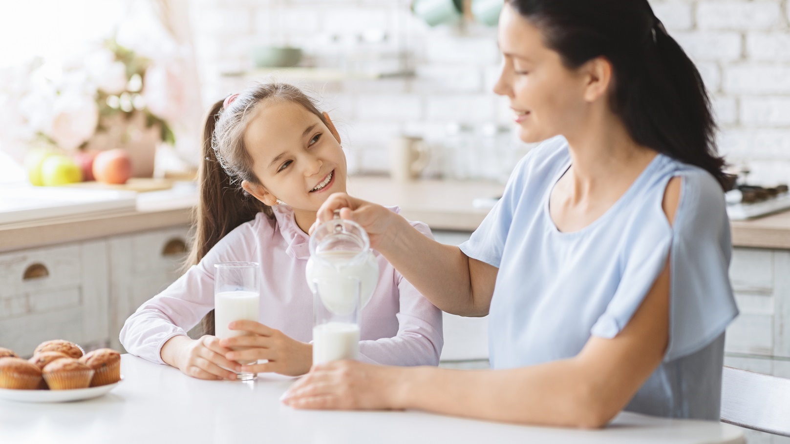 mother-and-daughter-drinking-milk-in-kitchen-toget-2021-08-26-16-33-38-utc