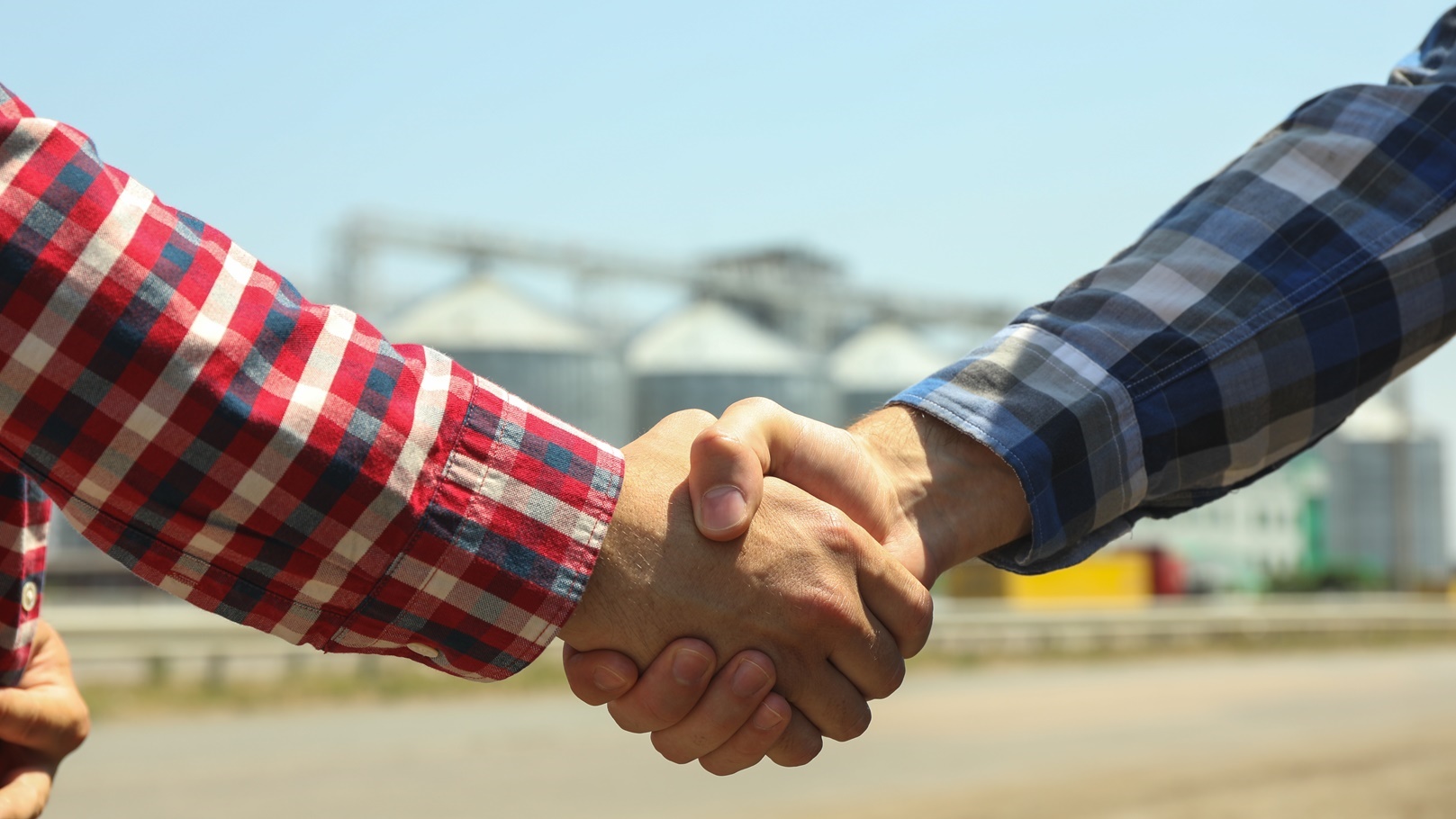 businessmen-shake-hands-against-silos-agriculture-2022-02-07-07-56-12-utc