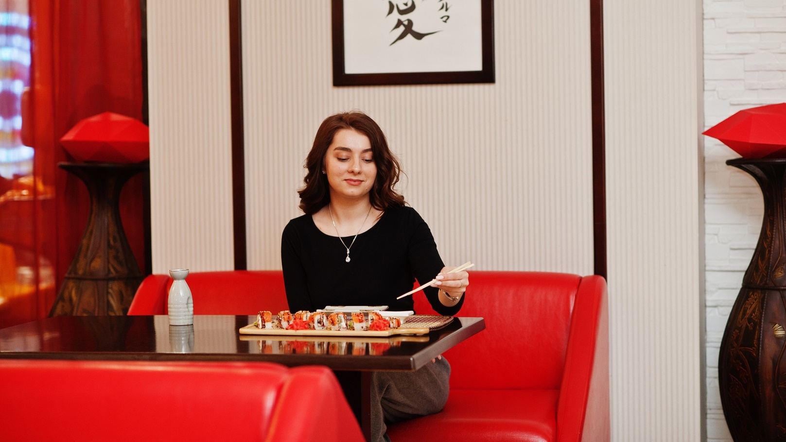 a-young-beautiful-girl-eating-sushi-on-traditional-2022-02-05-00-09-20-utc