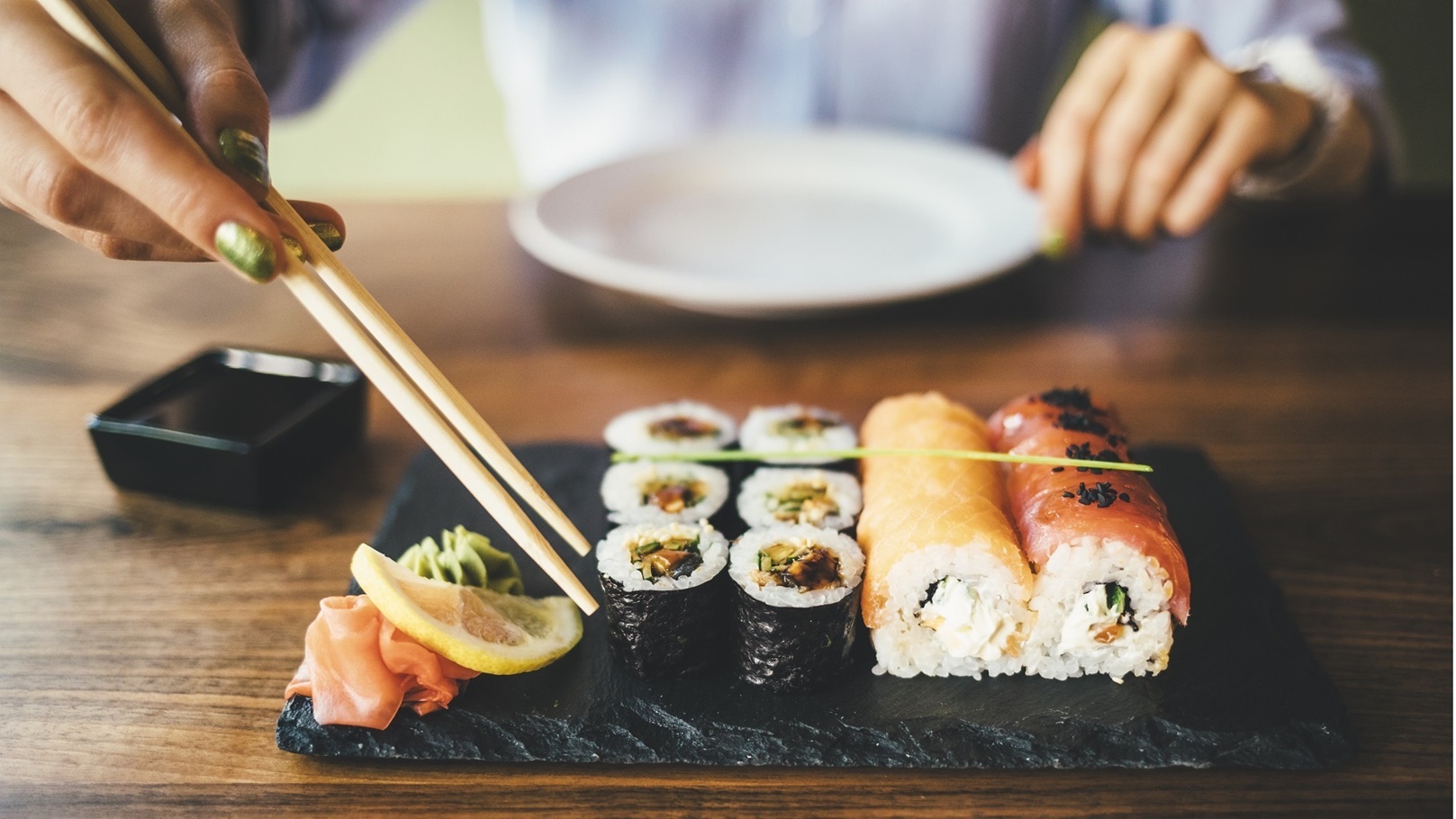 close-up-of-a-woman-eating-sushi-in-a-restaurant-2022-03-08-01-30-40-utc