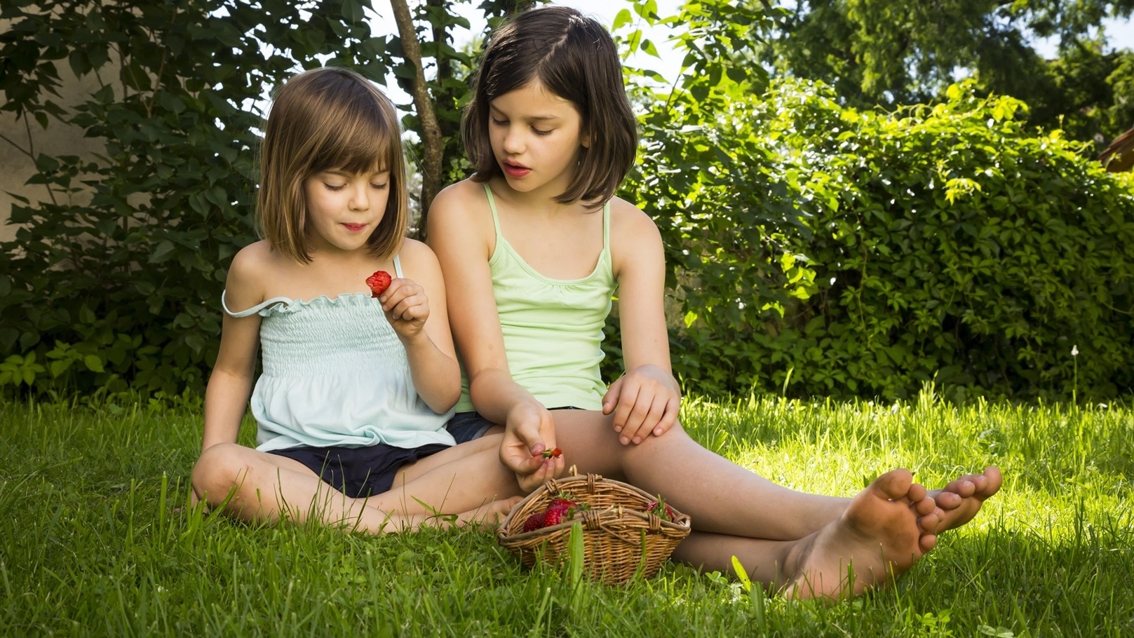two-sisters-sitting-together-on-a-meadow-eating-st-2022-03-08-01-25-46-utc