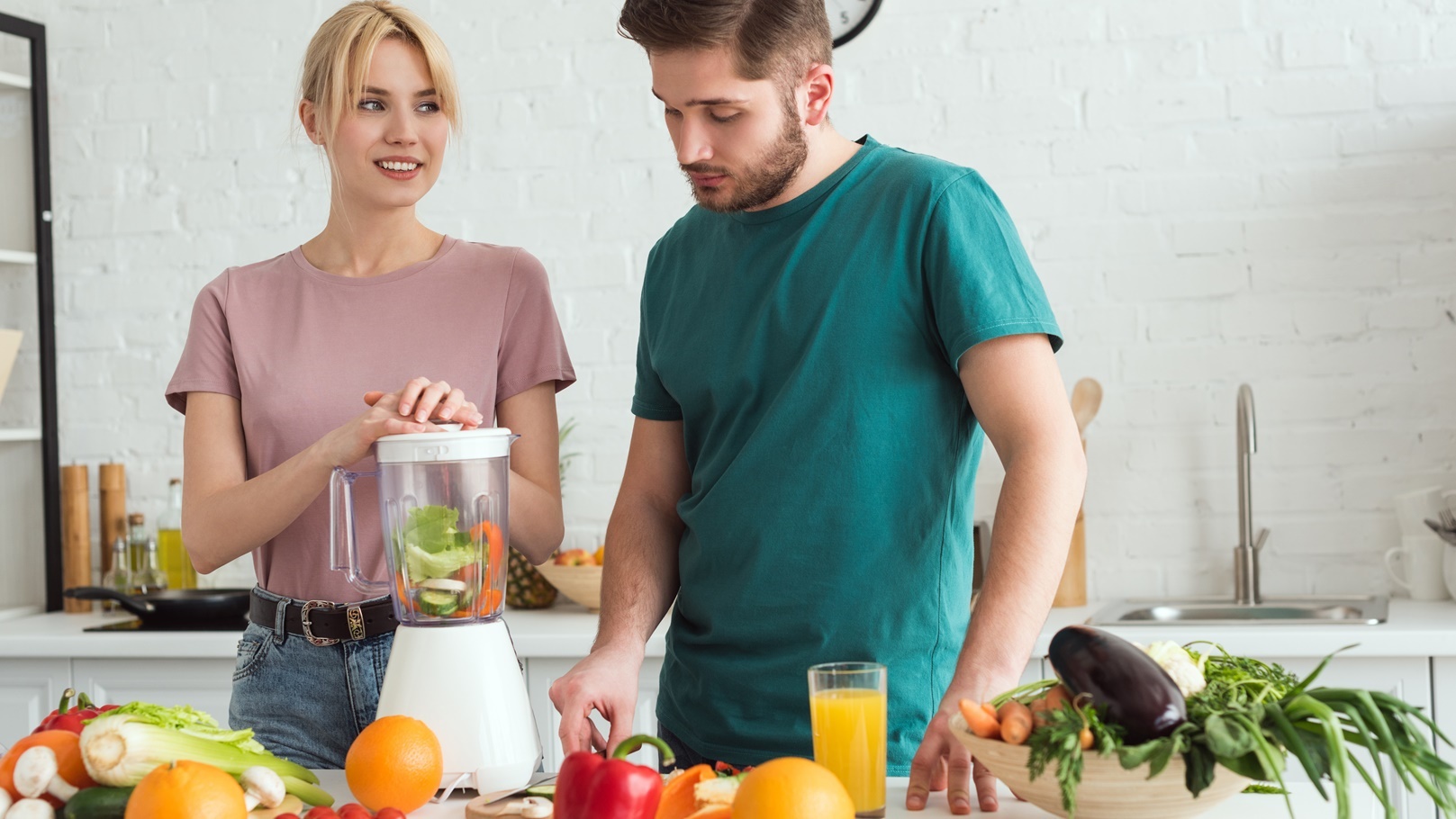 couple-of-vegans-preparing-vegetable-juice-with-ju-2021-09-03-05-16-59-utc
