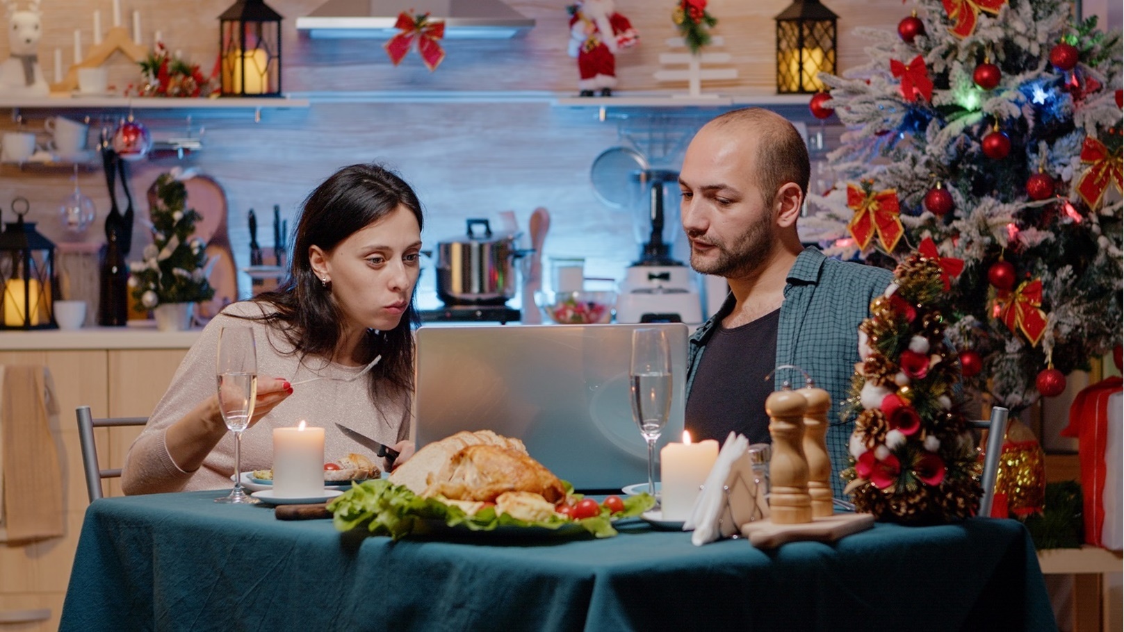 couple-looking-at-laptop-and-eating-festive-meal-2021-10-12-05-35-47-utc