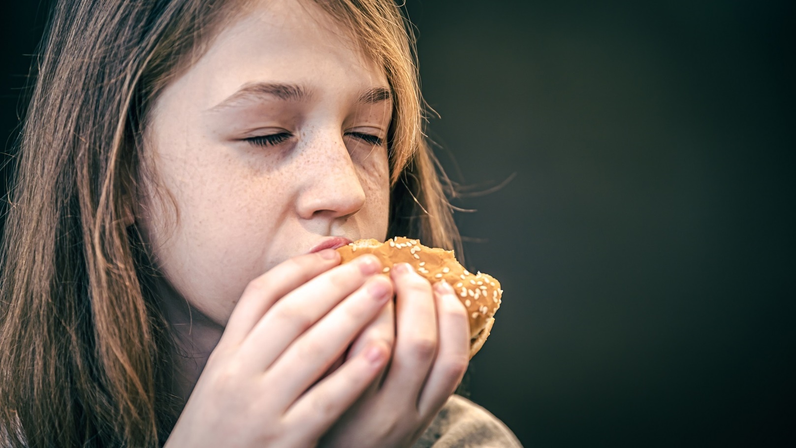 a-little-girl-with-freckles-eats-a-burger-2022-02-09-07-02-57-utc