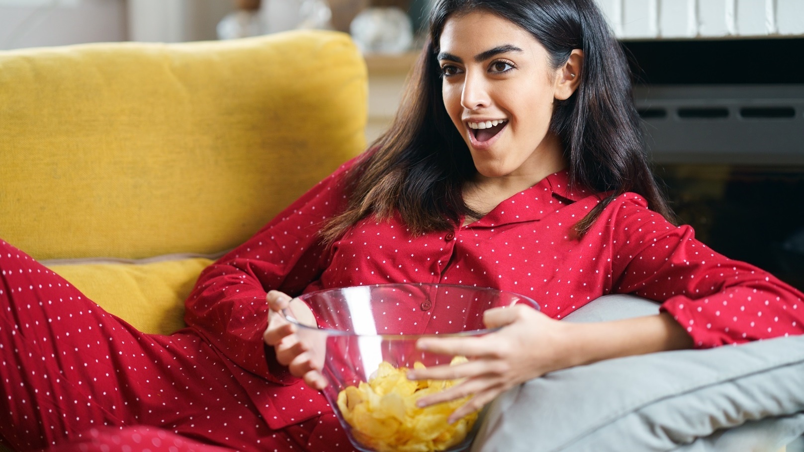 persian-woman-at-home-watching-tv-eating-chips-pot-2021-08-27-09-55-30-utc