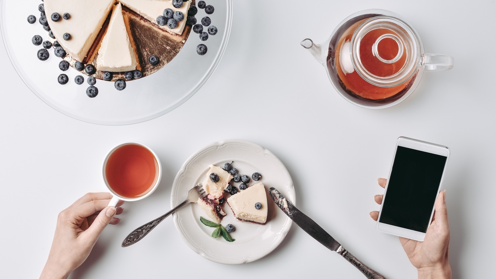 top-view-of-woman-eating-cheesecake-and-using-smar-2022-02-02-03-59-07-utc