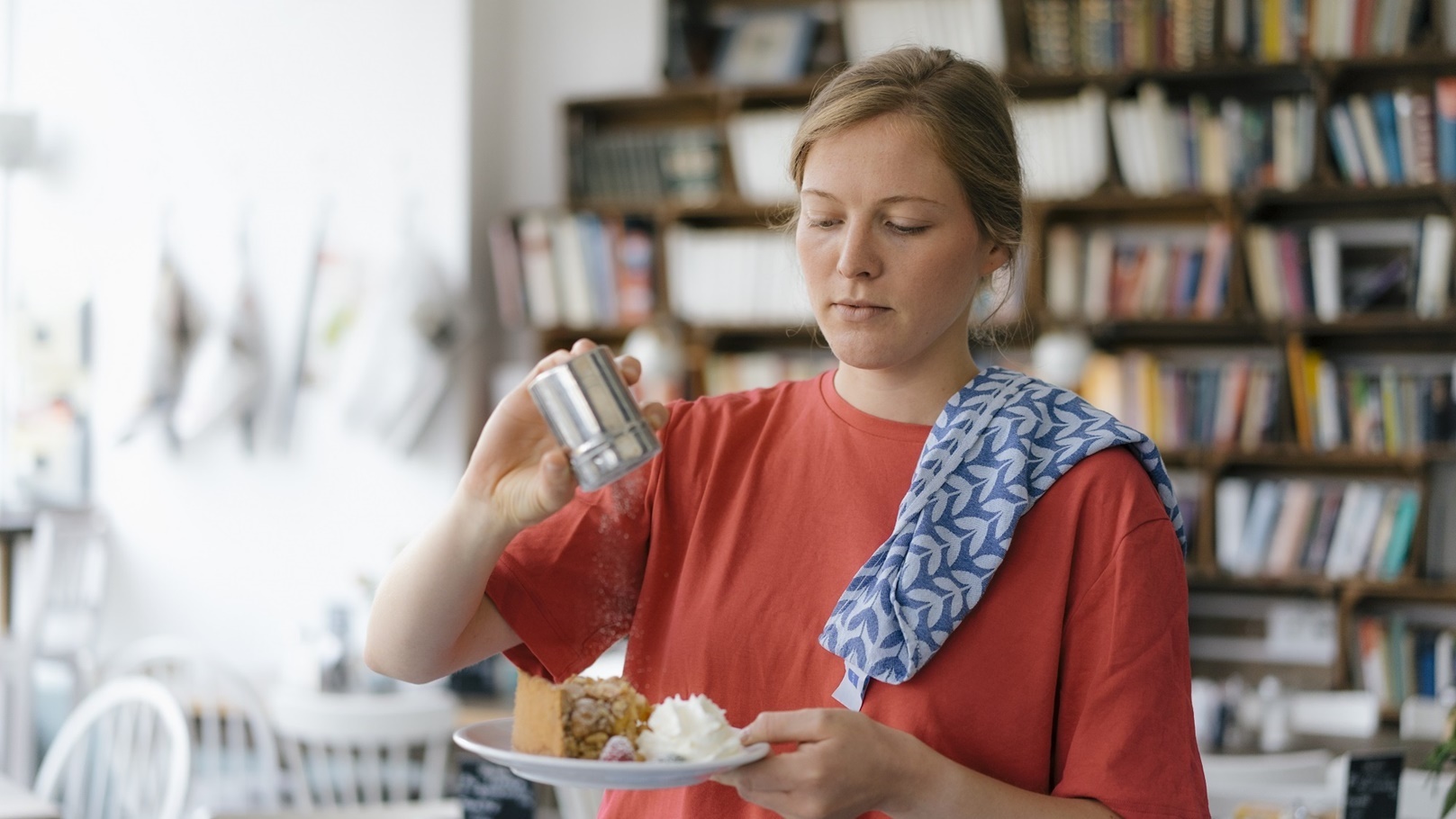 young-woman-serving-plate-with-cake-in-a-cafe-2022-03-08-01-27-09-utc