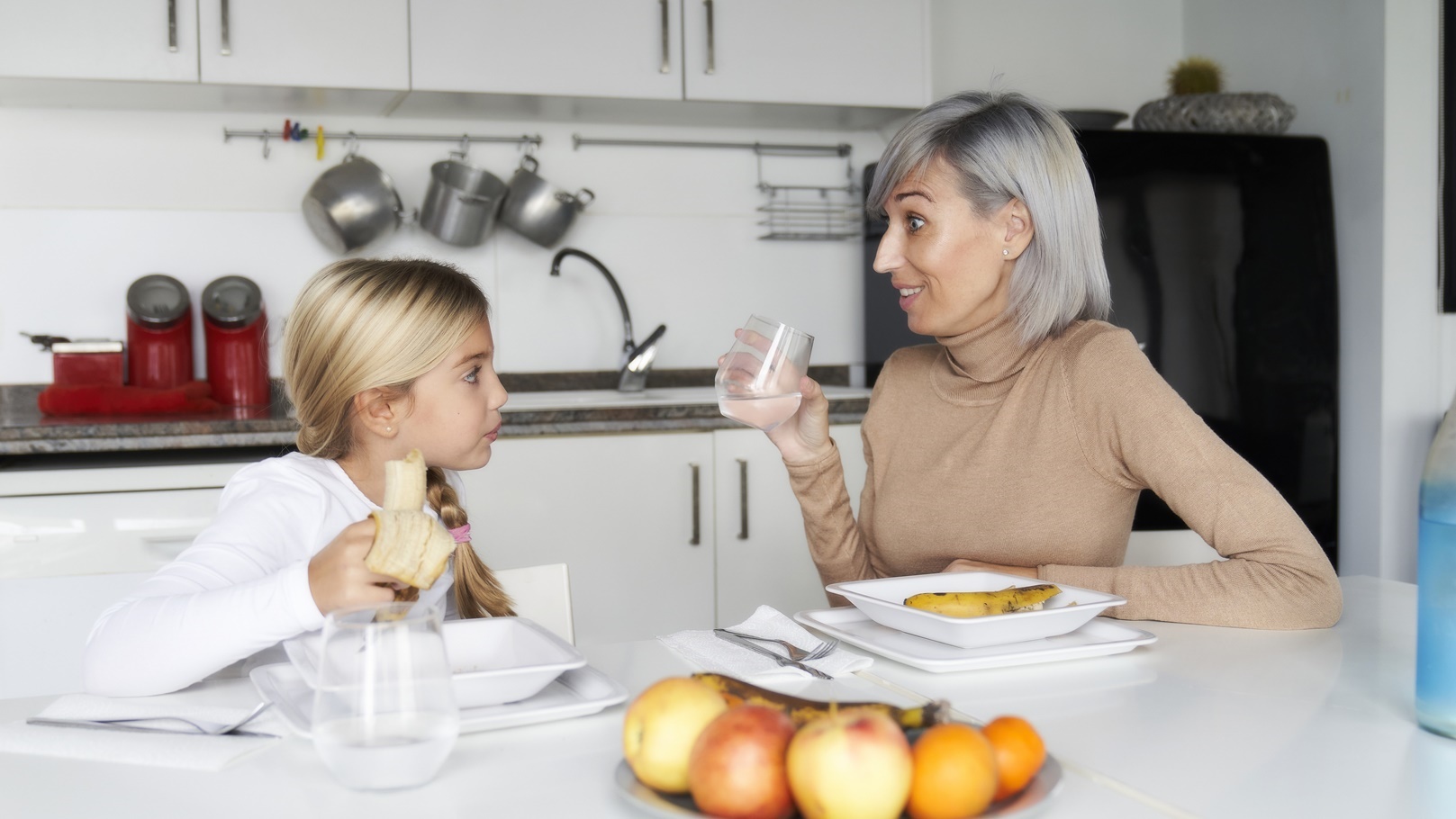 mother-and-daughter-eating-fruit-in-the-kitchen-f-2022-02-16-02-29-17-utc