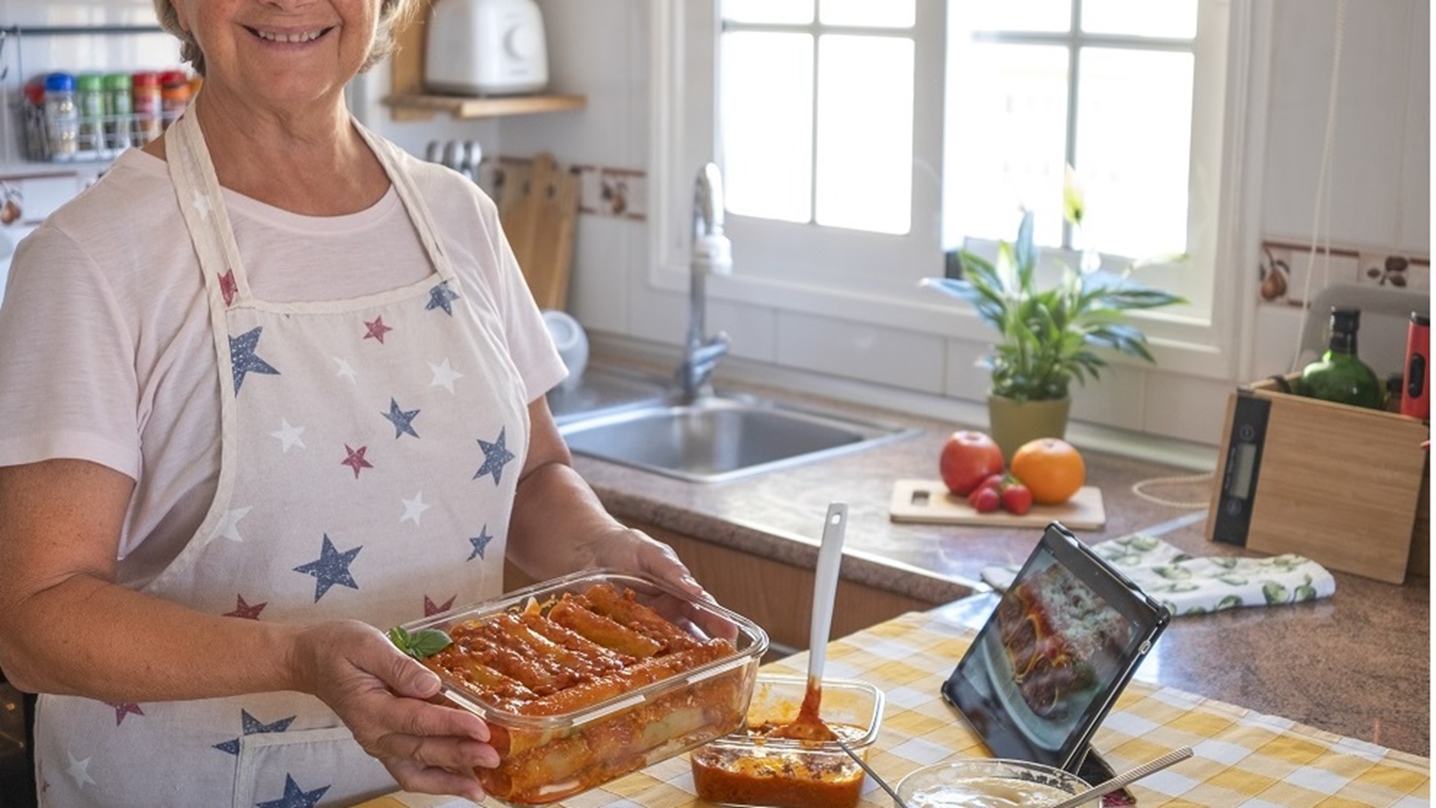 happy-senior-woman-shows-a-pan-with-homemade-stuff-2022-02-07-09-02-03-utc