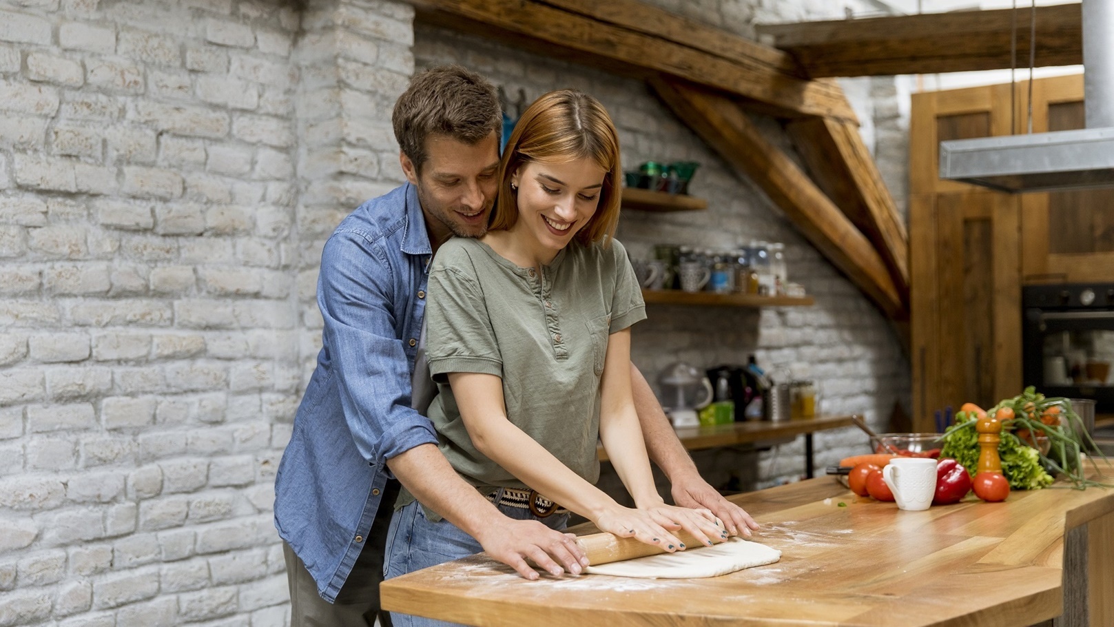 young-couple-caking-pizza-in-kitchen-together-2022-04-07-20-45-48-utc
