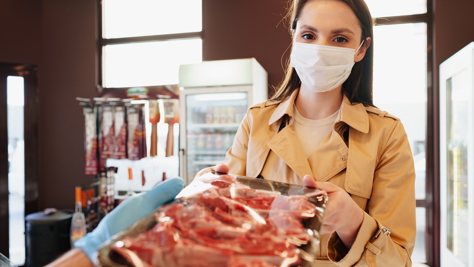 young-woman-in-medical-mask-buying-raw-meat-in-gro-2022-03-04-04-16-17-utc