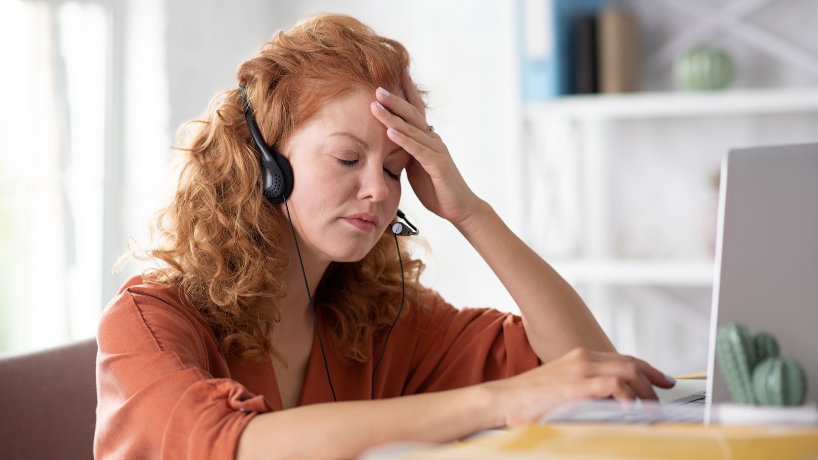 curly-woman-touching-her-forehead-while-feeling-di-2021-09-03-20-26-00-utc