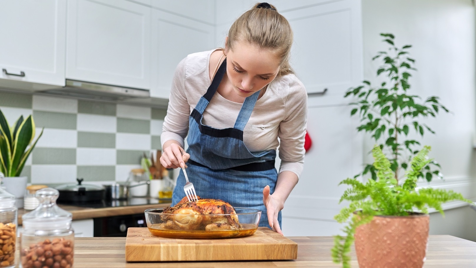 woman-cooking-baked-chicken-at-home-in-the-kitchen-2022-01-27-16-35-54-utc