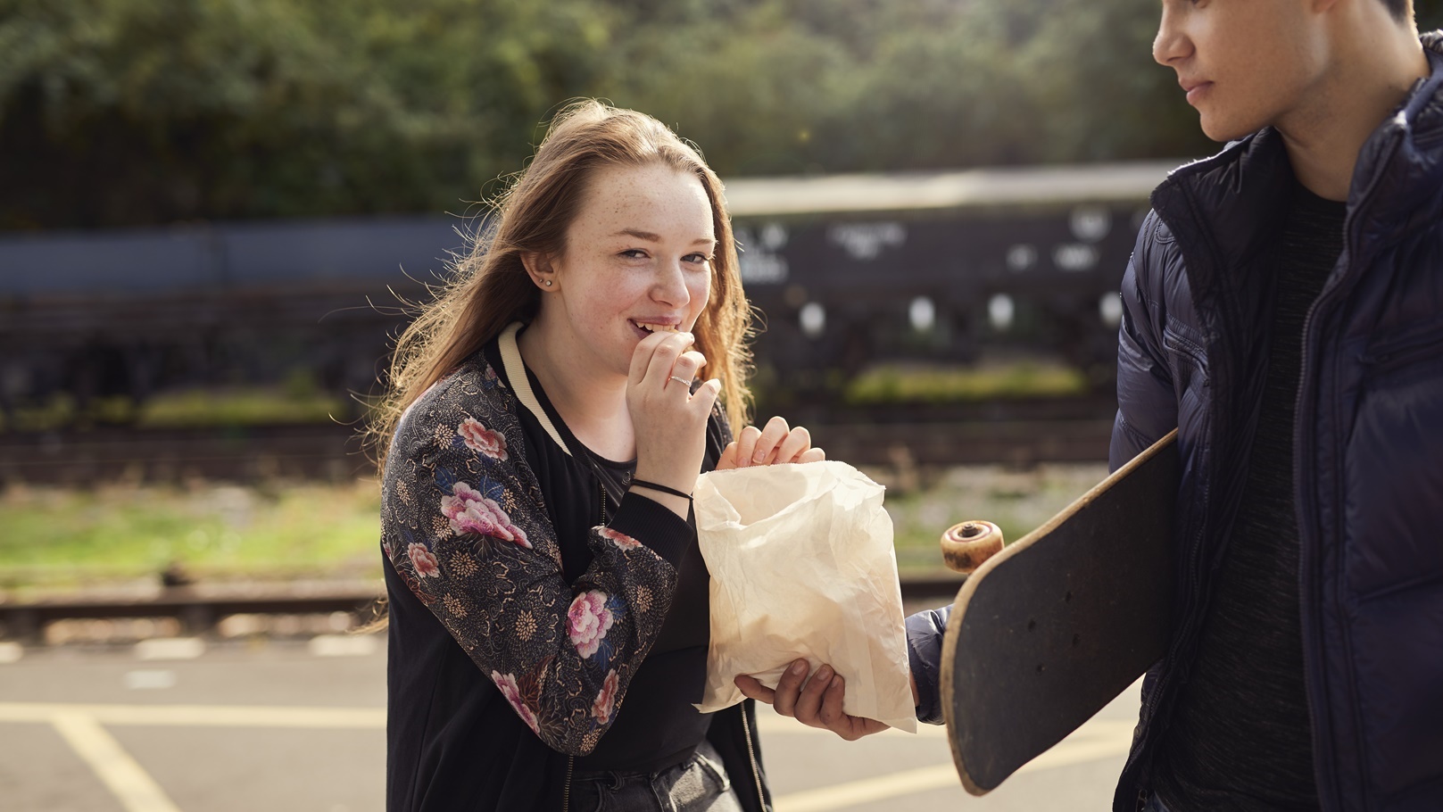 young-man-sharing-bag-of-chips-with-young-woman-2022-03-04-01-47-04-utc