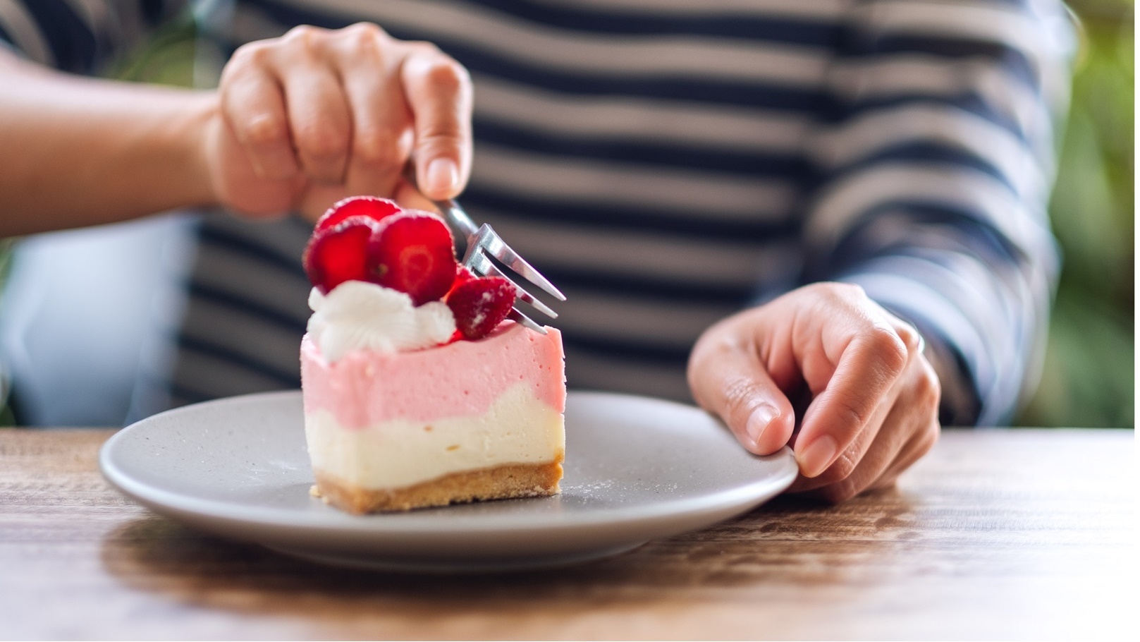 closeup-image-of-a-woman-eating-a-strawberry-chees-2021-10-21-03-31-24-utc