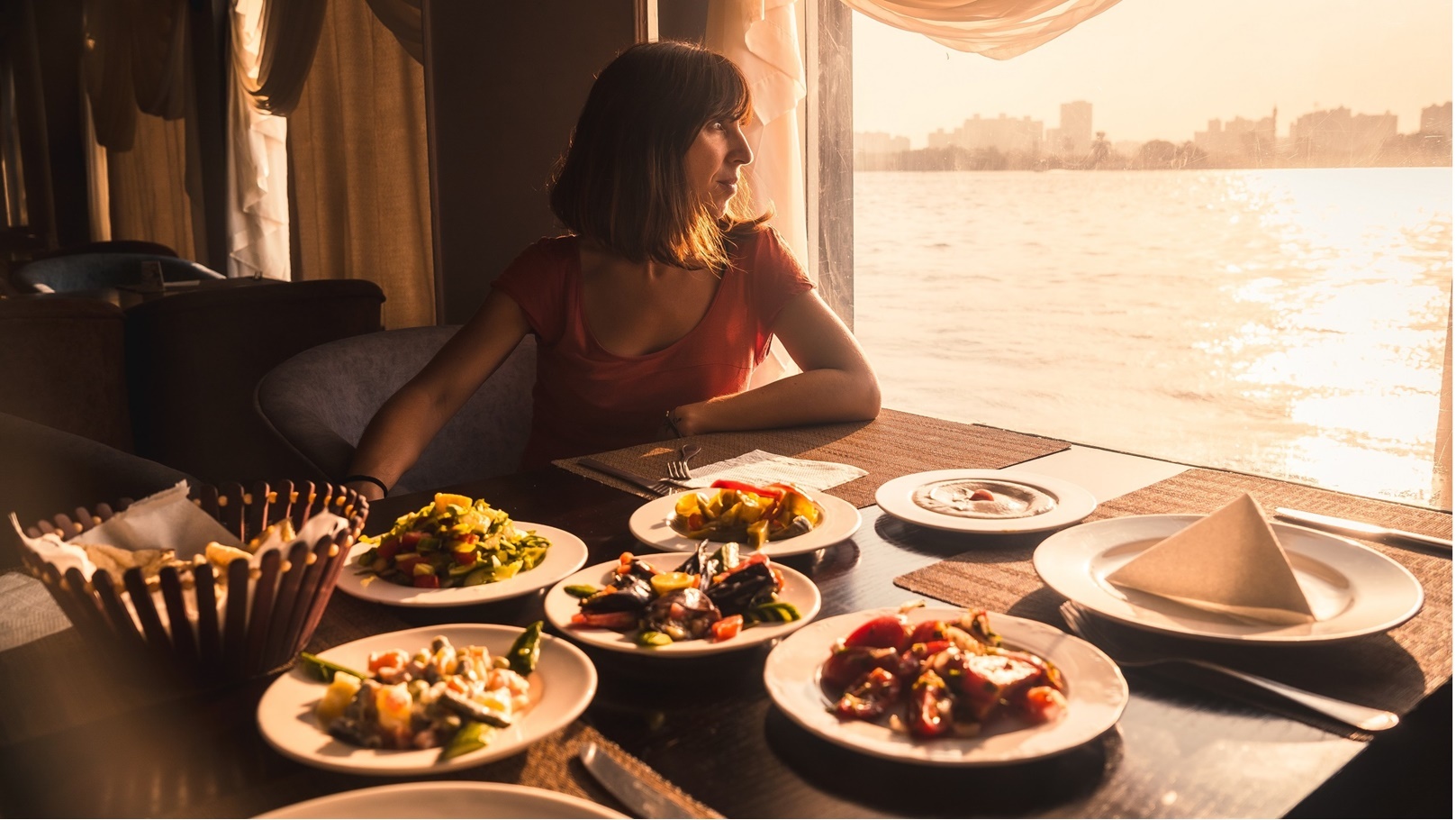 a-young-tourist-having-dinner-on-a-boat-on-the-nil-2022-03-09-22-07-27-utc