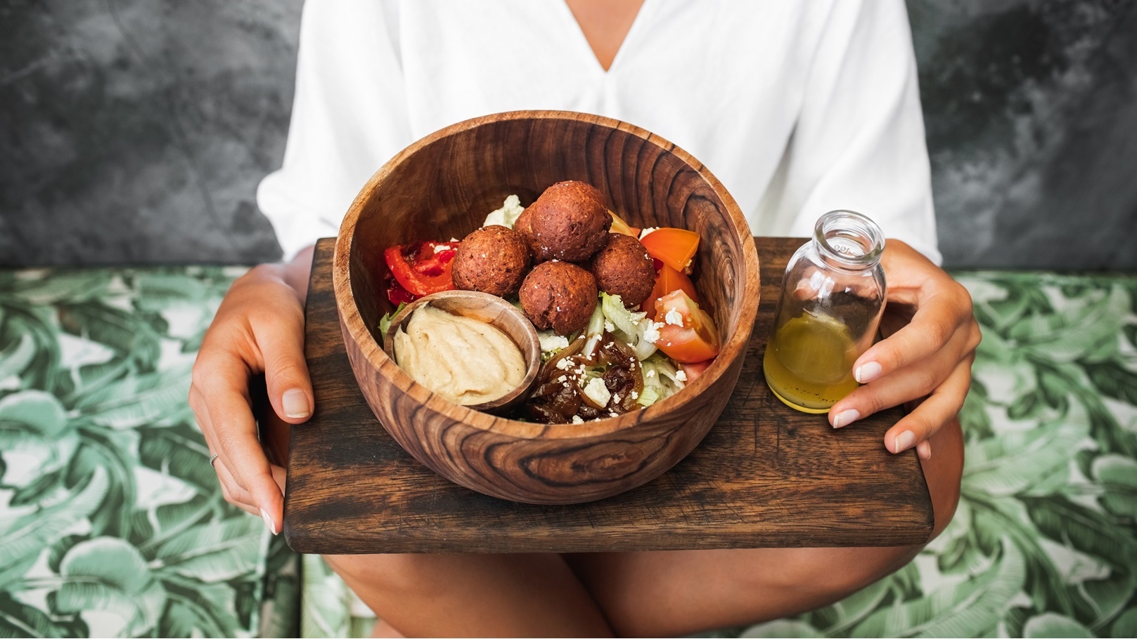 woman-eating-falafel-balls-hummus-and-fresh-salad-2021-08-30-09-29-15-utc