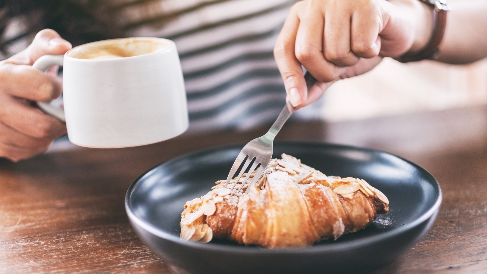 closeup-image-of-a-woman-drinking-coffee-and-eatin-2022-01-18-23-35-41-utc