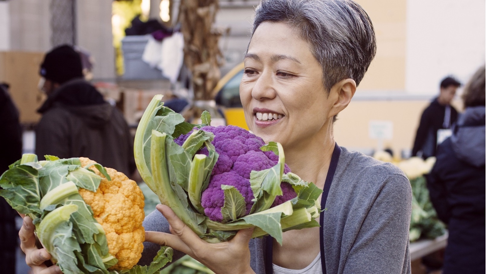 smiling-mature-woman-choosing-cauliflowers-at-farm-2022-05-26-03-40-02-utc