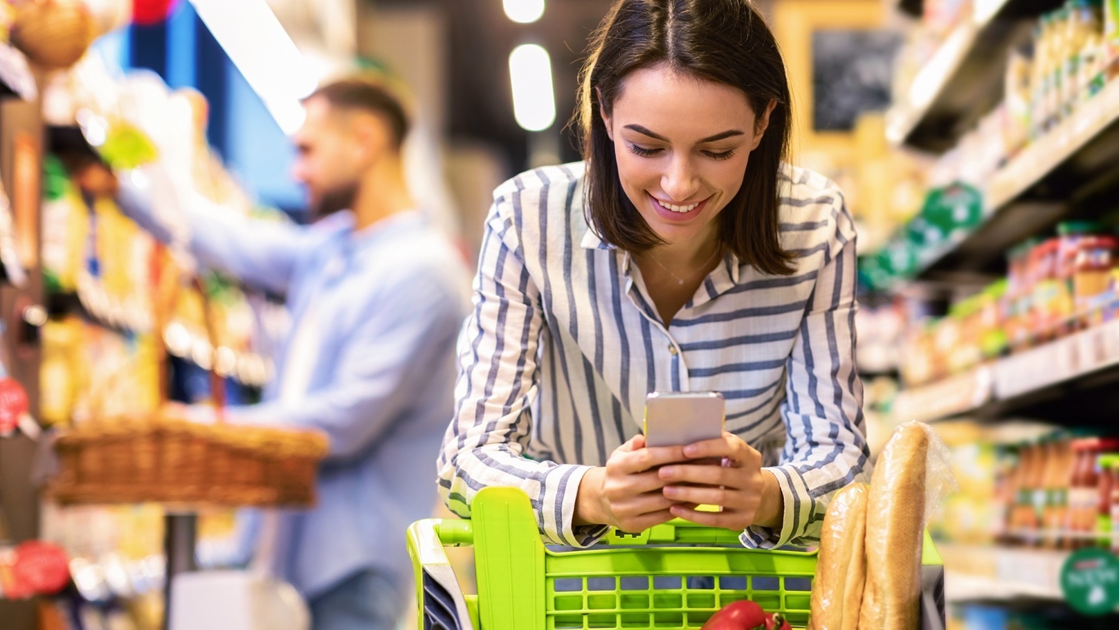 young-lady-with-mobile-phone-shopping-at-super-mar-2021-09-01-16-39-44-utc