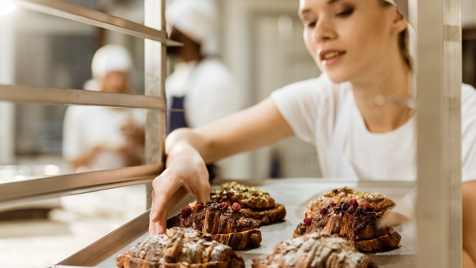 beautiful-female-baker-holding-tray-of-freshly-bak-2022-01-18-23-58-03-utc