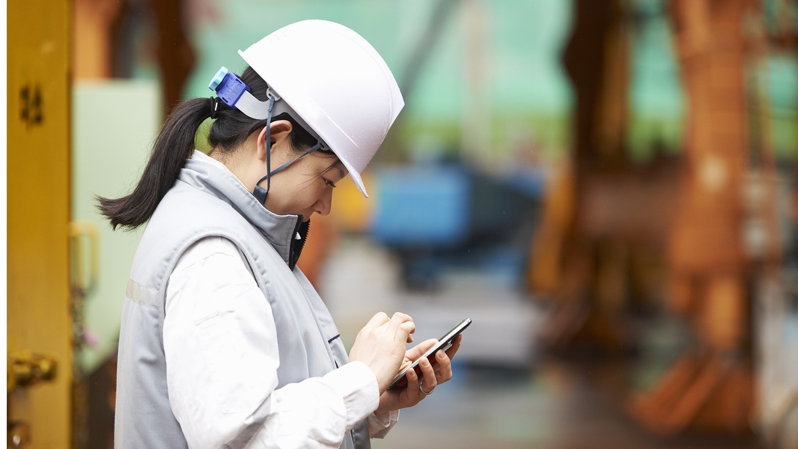 worker-using-smartphone-at-shipyard-goseong-gun-2022-03-08-00-14-34-utc