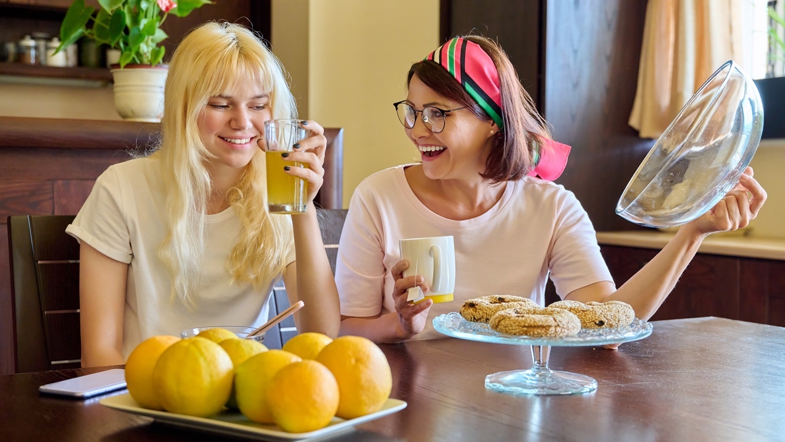 mom-and-teenage-daughter-eat-together-in-the-kitch-2022-01-14-00-09-26-utc
