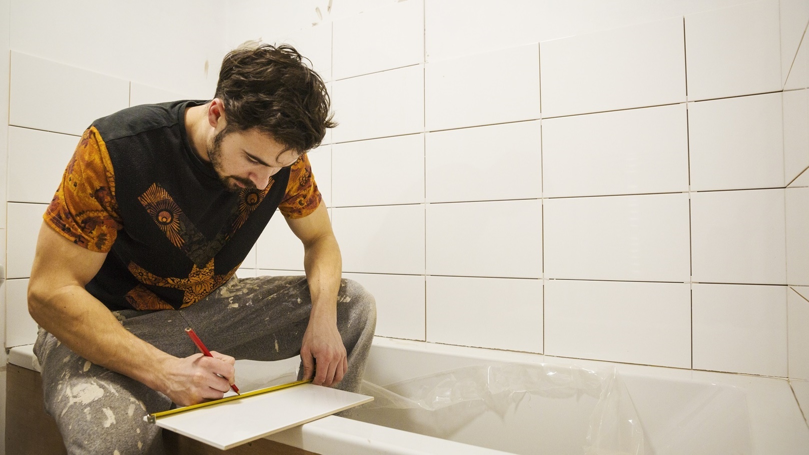a-builder-tiler-working-in-a-bathroom-marking-a-2022-03-04-02-16-38-utc